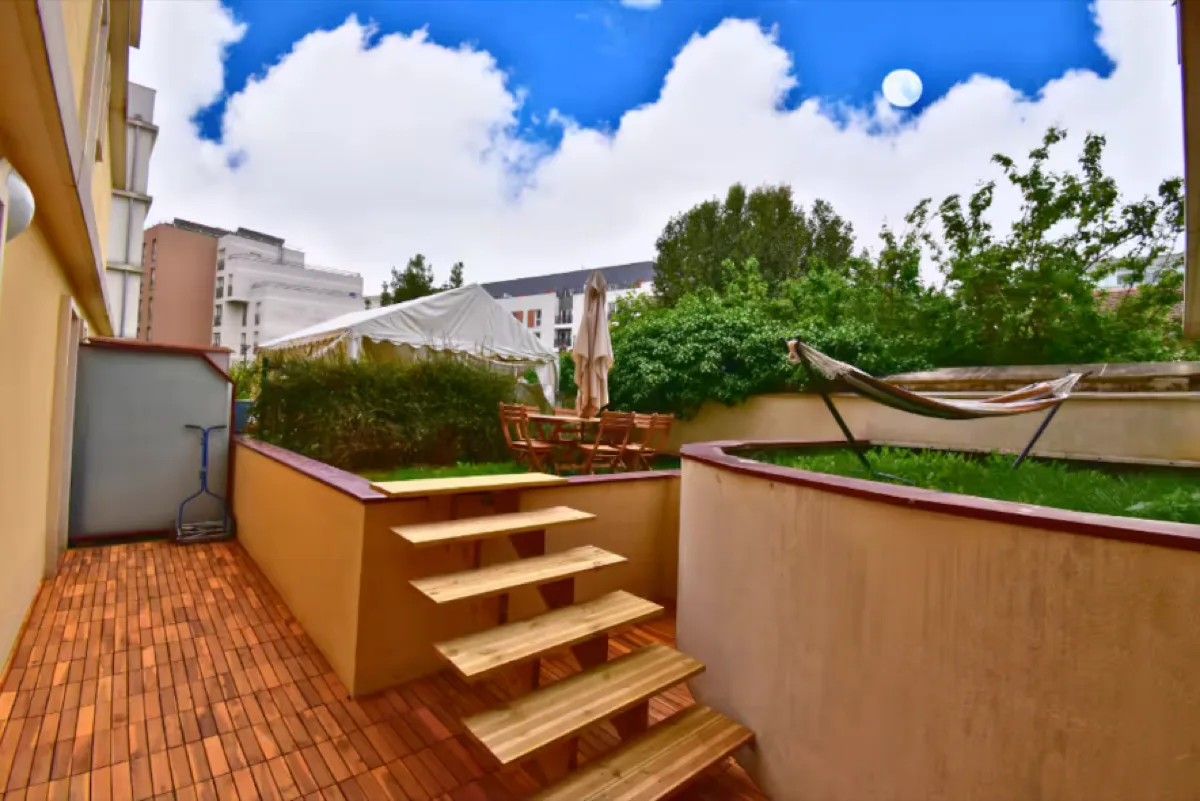 Terrasse après : jardin entretenu, gazon, hamac tendu, escaliers en bois, espace extérieur aménagé