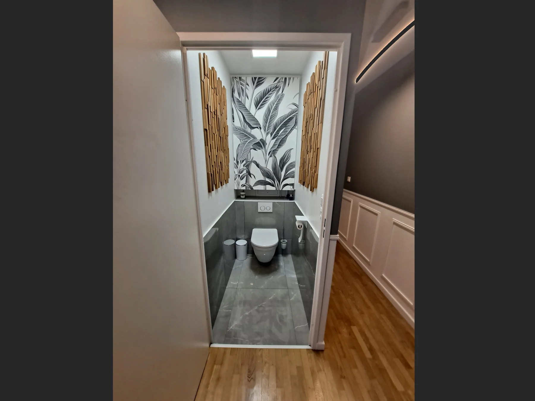Toilettes après rénovation : papier peint végétal, soubassement, ambiance plus soignée